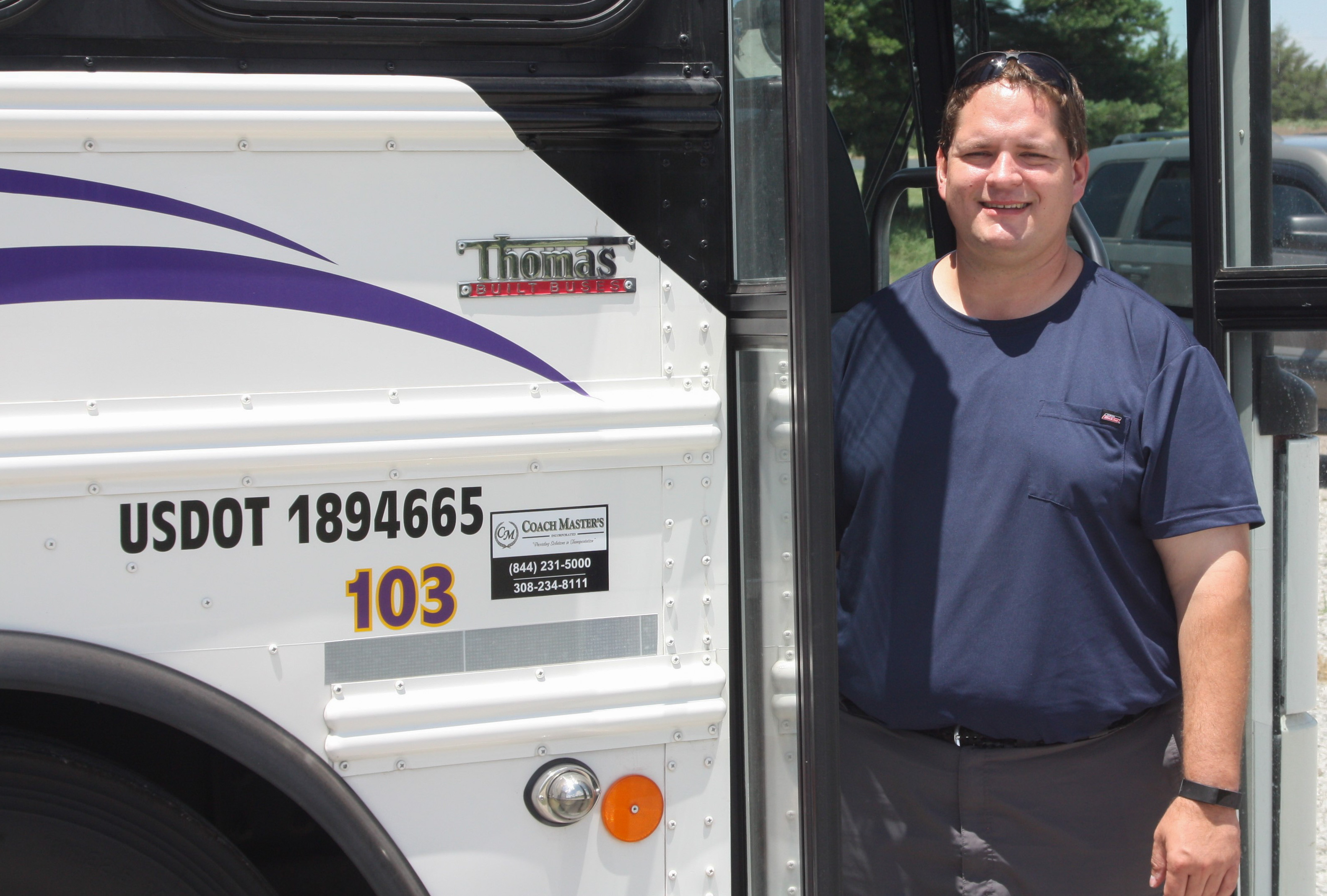 Fleet Manager Justin Hergert standing in the door of one of the DC3 buses.