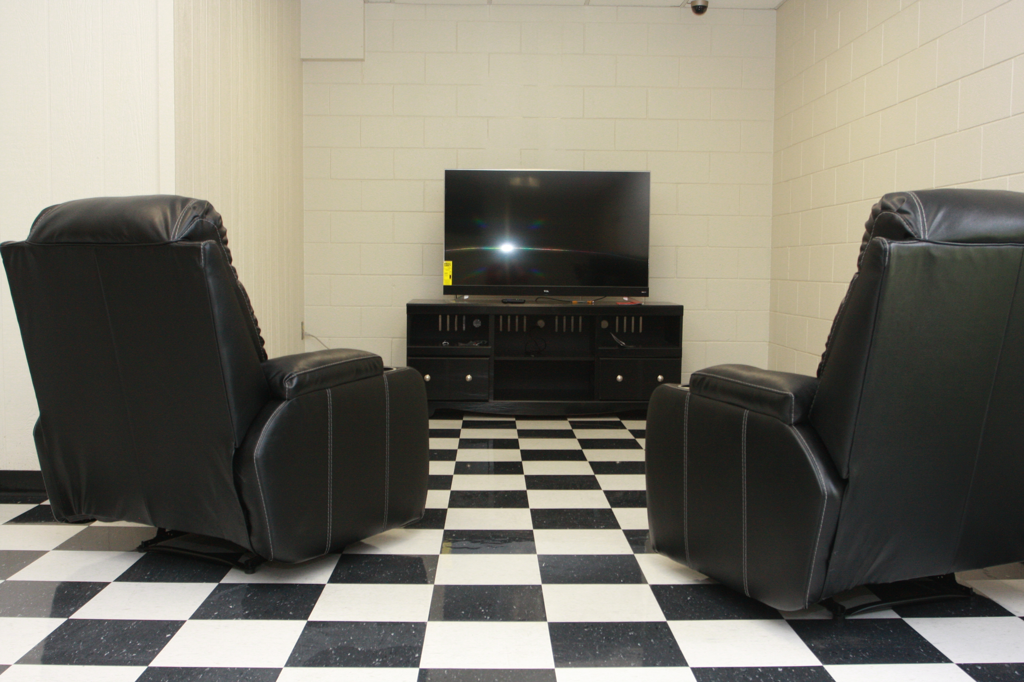 New leather recliners facing an entertainment center with LCD television in the recreation area of the Conq Corral