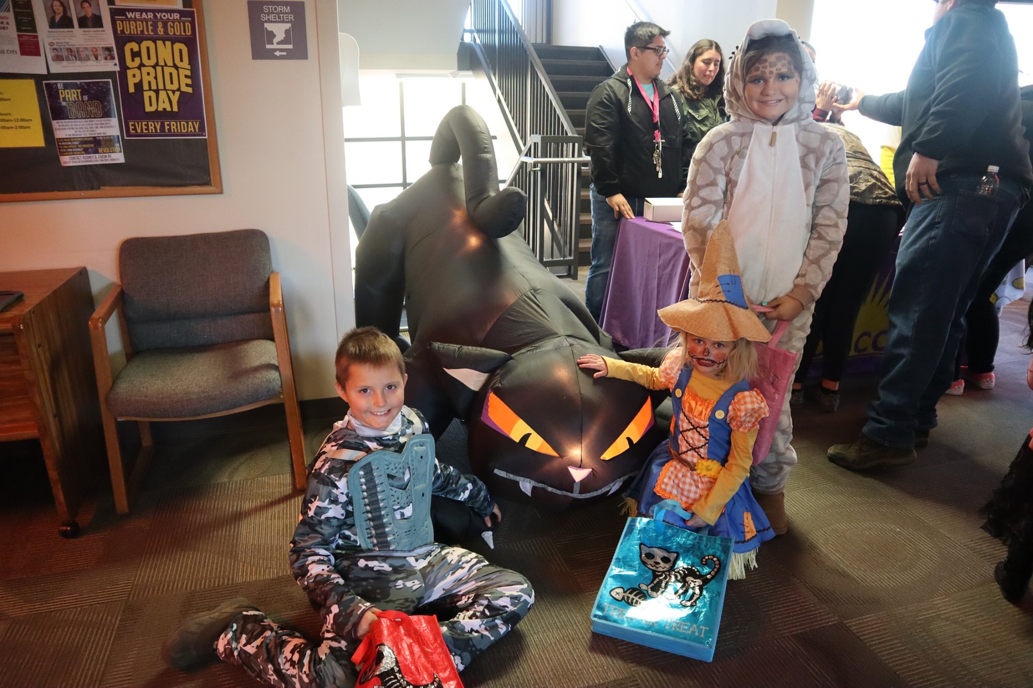 Children pet a giant inflatable cat during the 2019 community trick or treat